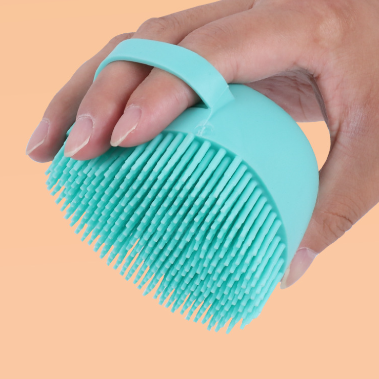 Silicone Bath Brush in blue held in hand